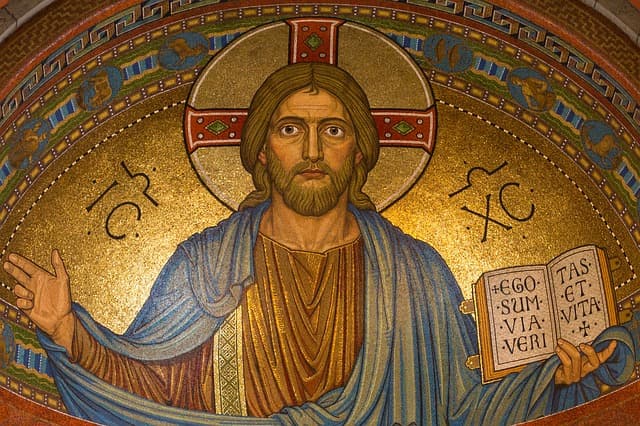 Mosaico dourado de Cristo com a mão erguida em bênção, segurando o livro aberto